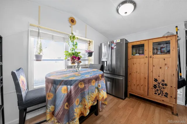 a dining room with furniture potted plants and wooden floor