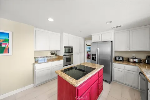 a large bedroom with a large bed a flat tv screen and dresser