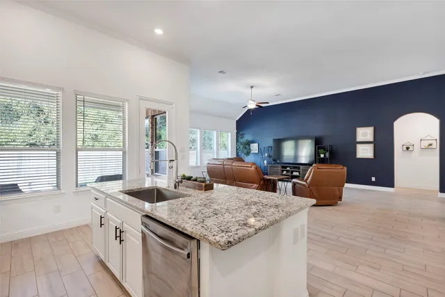 a open kitchen with stainless steel appliances granite countertop a sink and a large window