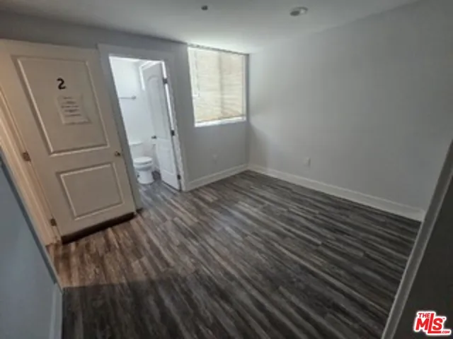 a view of a room with wooden floor and white walls