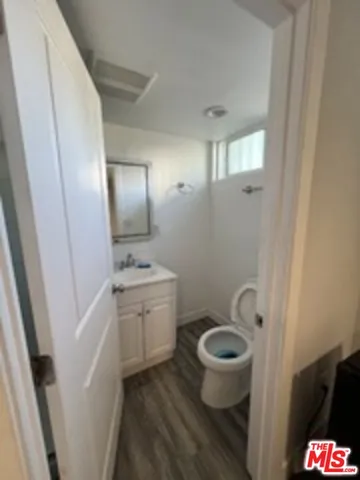 a bathroom with a granite countertop toilet a sink and a mirror