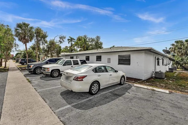 a white car parked in front of a house