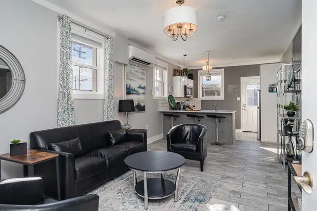 a living room with furniture a dining table and a chandelier