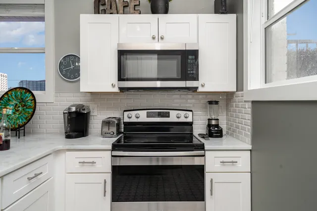 a kitchen with cabinets stainless steel appliances and wooden floor