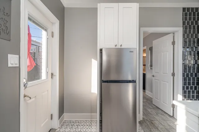 a white refrigerator freezer and a wooden floor