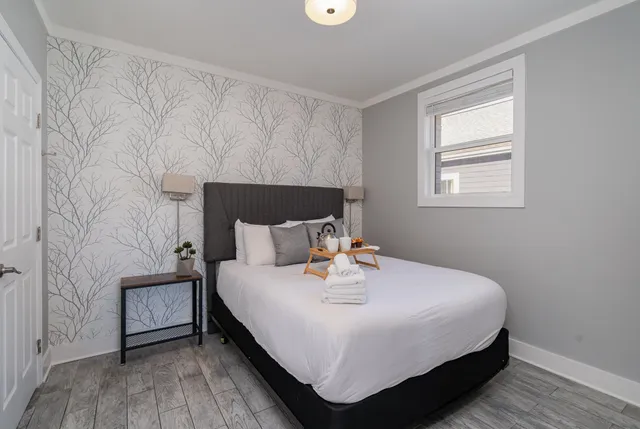 a bedroom with a bed and wooden floor