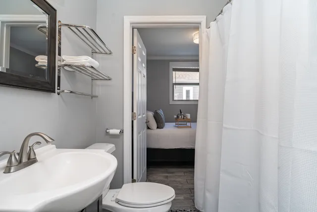 a bathroom with a sink a toilet and shower