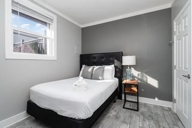 a bedroom with a bed and wooden floor