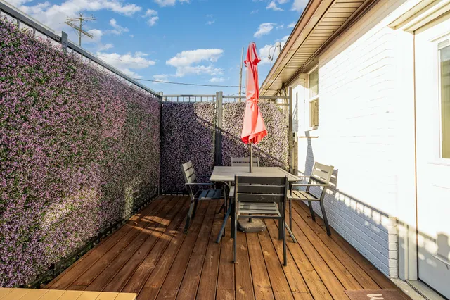 a view of balcony with wooden floor and seating