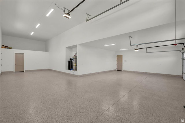 1620 Belayer Drive St. George, UT 84770 - Photo 39 of 51 Spacious garage featuring a durable epoxy floor, high ceilings, multiple overhead LED light fixtures, and a dedicated storage loft