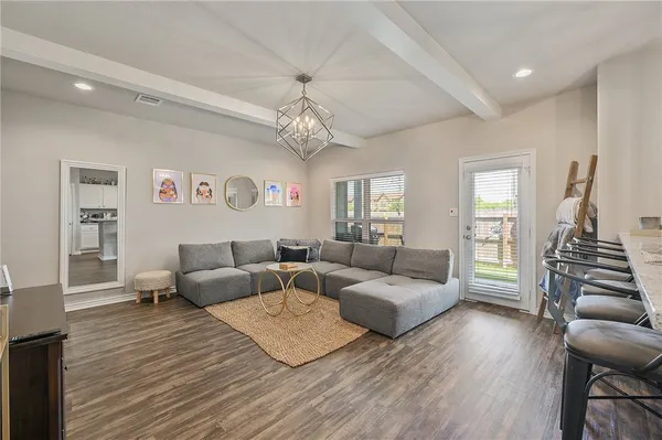 a living room with furniture and a chandelier