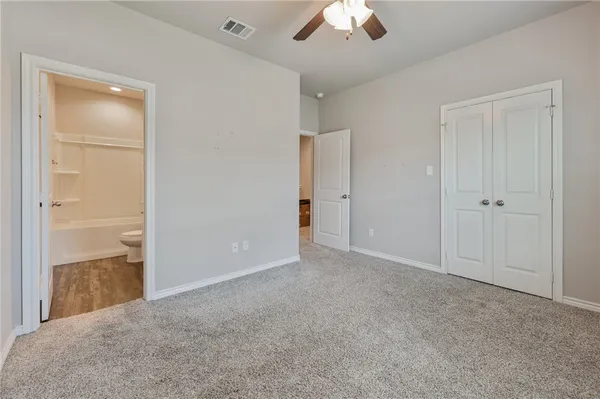 a view of an empty room and a chandelier fan
