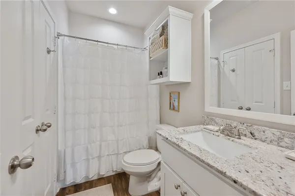 a bathroom with a granite countertop sink toilet and shower