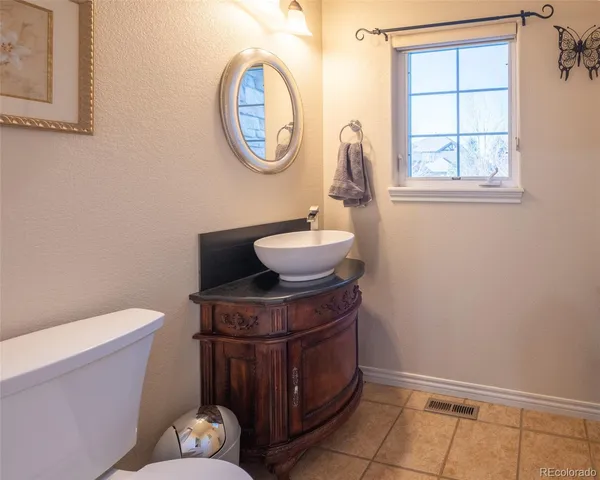 a bathroom with a toilet mirror vanity and window