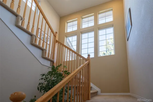a view of staircase with lots of frames on wall and a window