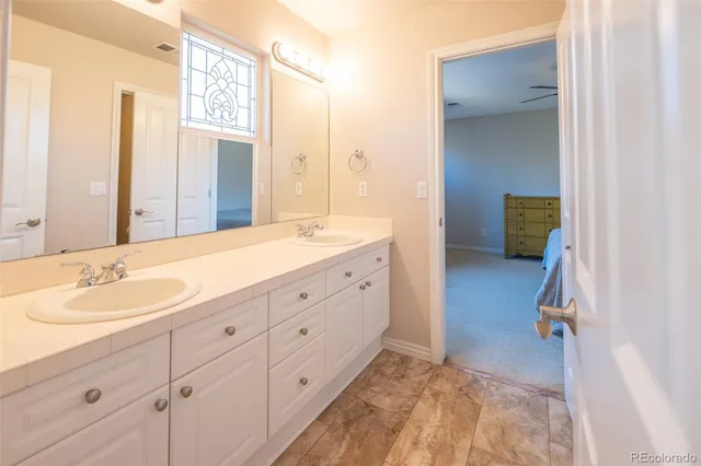 a spacious bathroom with a double vanity sink and a mirror
