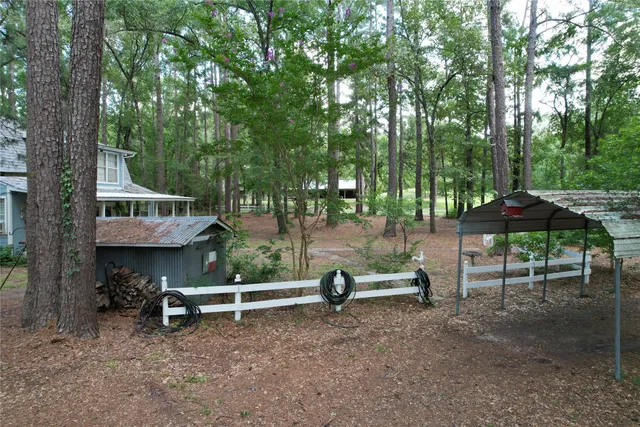 a view of backyard with outdoor seating and trees