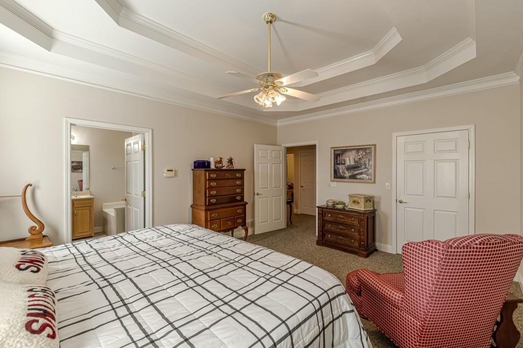 4346 Leola Road Douglasville, GA 30135 - Photo 33 of 59 a bedroom with a bed dresser and a chandelier