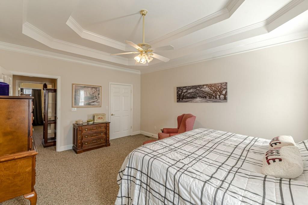 4346 Leola Road Douglasville, GA 30135 - Photo 34 of 59 a bedroom with a large bed and a chandelier