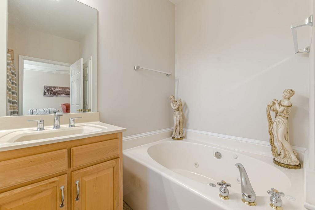 4346 Leola Road Douglasville, GA 30135 - Photo 38 of 59 a bathroom with a tub sink and mirror