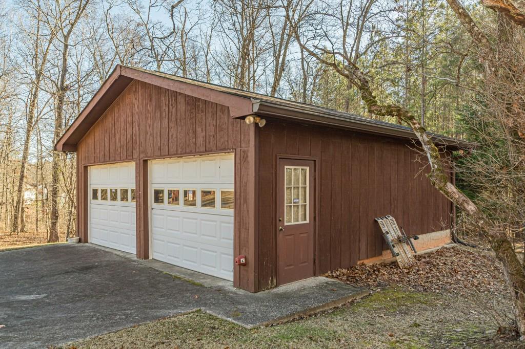 4346 Leola Road Douglasville, GA 30135 - Photo 54 of 59 a backyard of a house with large trees and brick wall