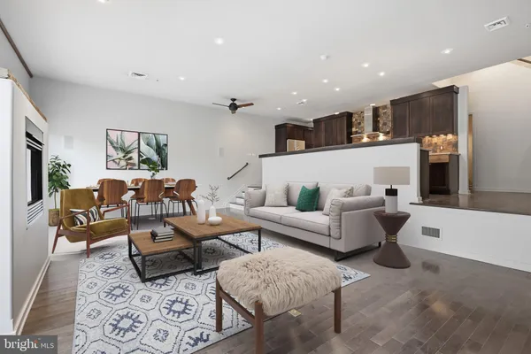 a living room with furniture kitchen view and a large window