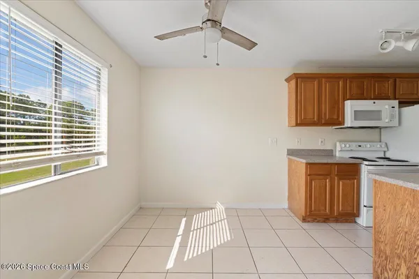 a kitchen with granite countertop a stove a sink and a refrigerator