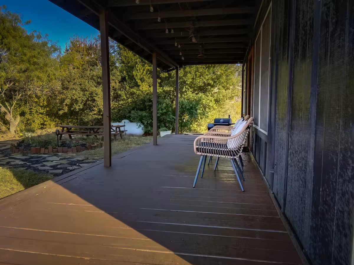 16107 Fagerquist Road Del Valle, TX 78617 - Photo 12 of 17 A spacious covered porch overlooks a verdant landscape, inviting relaxation and outdoor enjoyment.