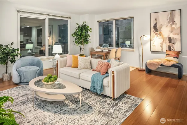 a living room with furniture a table and a large window