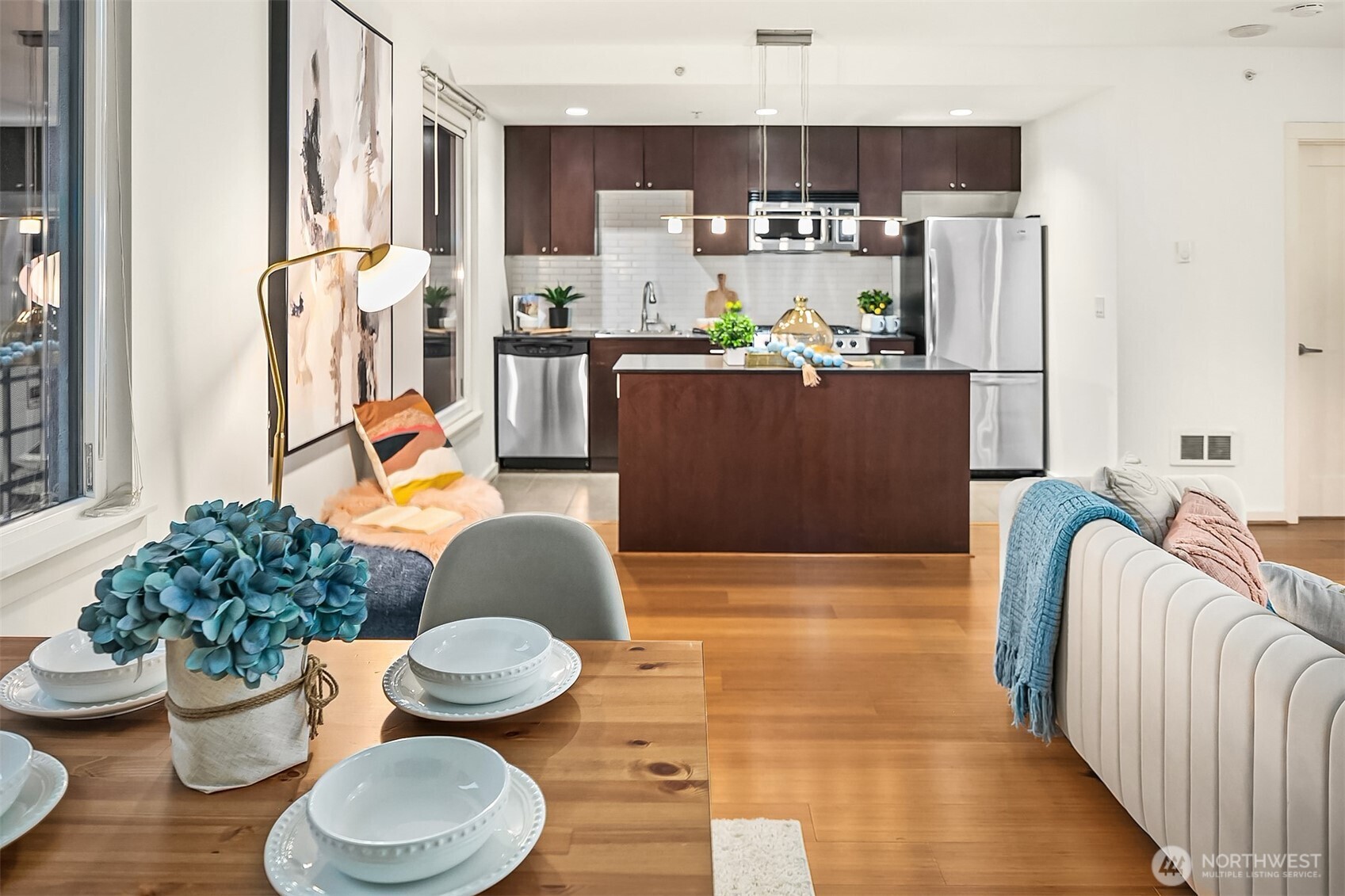 76 Cedar Street, Unit 405 Seattle, WA 98121 - Photo 7 of 32 a kitchen with stainless steel appliances a dining table and chairs