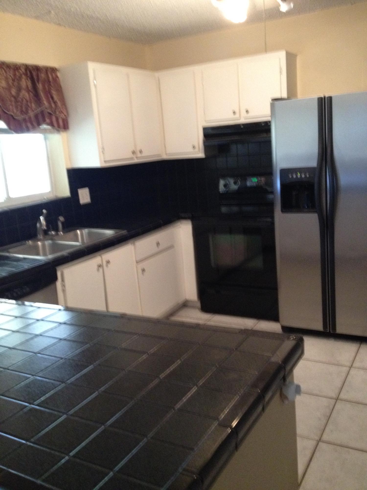 11198 Mandarin Street Boca Raton, FL 33428 - Photo 6 of 22 a kitchen with stainless steel appliances a sink a stove and a refrigerator