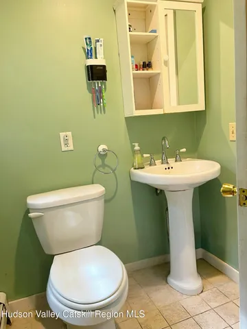 a bathroom with a sink toilet and a mirror