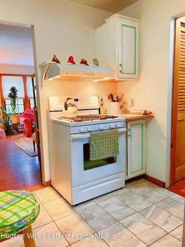 a utility room with stainless steel appliances granite countertop a stove a sink and a refrigerator