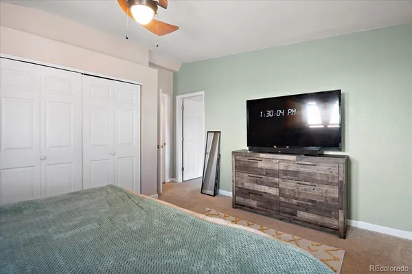 a living room with flat screen tv and a ceiling fan