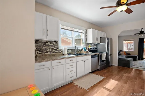 a kitchen with stainless steel appliances granite countertop a stove a sink dishwasher and a refrigerator
