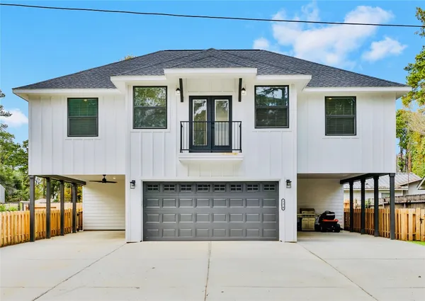 a front view of a house with glass windows and garage