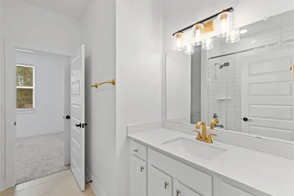 a bathroom with a granite countertop sink mirror and shower