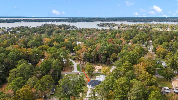 an aerial view of a house with a yard and lake view