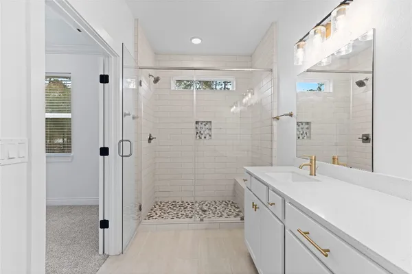 a bathroom with a shower sink and mirror