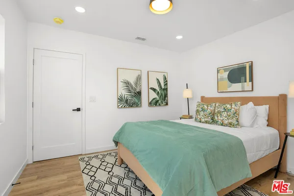a bedroom with a bed and a painting on the wall