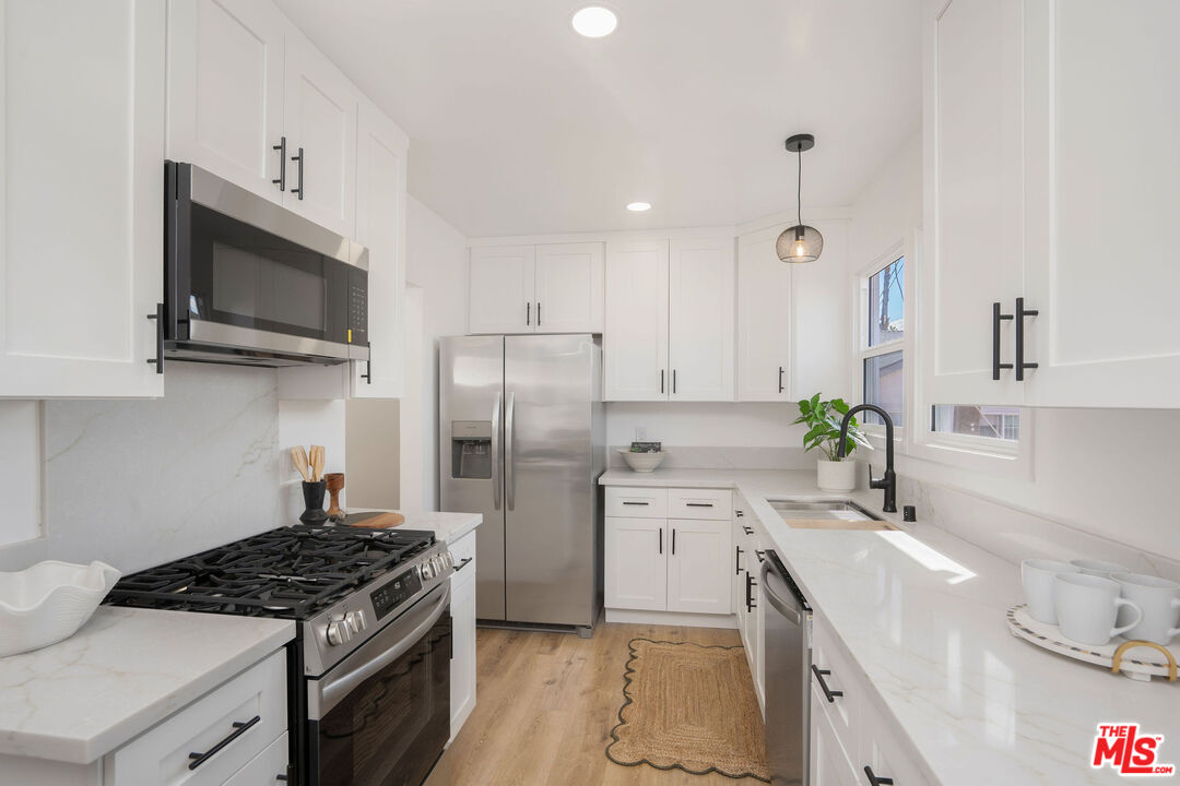 5418 South Rimpau Boulevard Los Angeles, CA 90043 - Photo 18 of 23 a kitchen with stainless steel appliances a stove a sink and a microwave