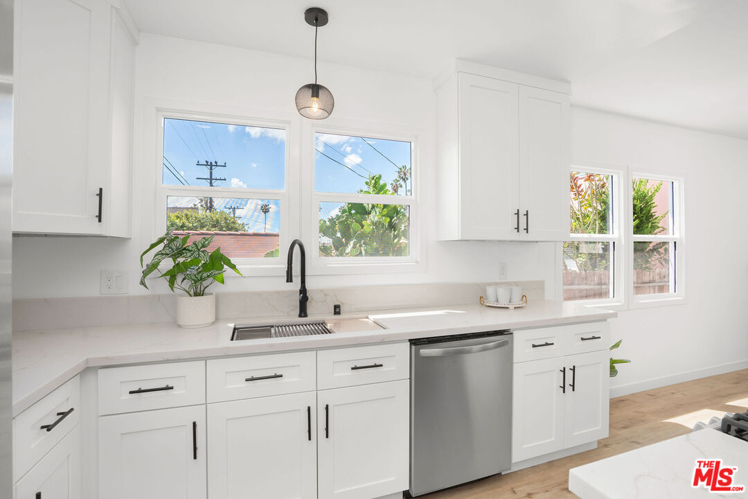 5418 South Rimpau Boulevard Los Angeles, CA 90043 - Photo 19 of 23 a kitchen with white cabinets a sink and a window