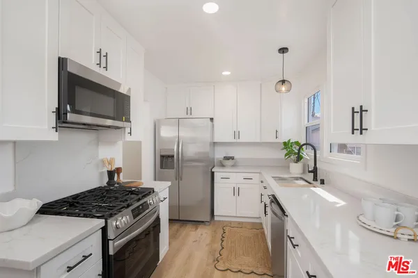 a kitchen with stainless steel appliances a stove a sink and a microwave