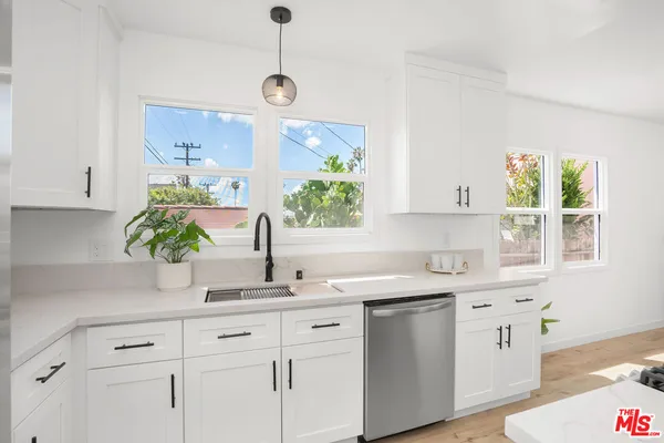 a kitchen with white cabinets a sink and a window