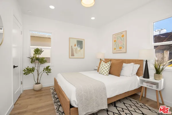 a bedroom with a bed and a potted plant