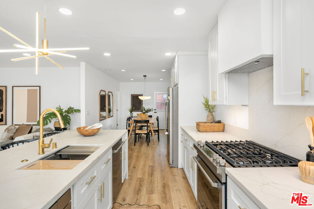 5418 South Rimpau Boulevard Los Angeles, CA 90043 - Photo 6 of 23 a kitchen with a sink stove and cabinets