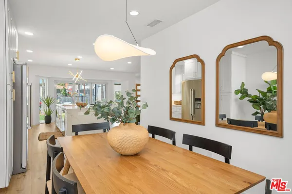 a large white kitchen has a table and chairs in it