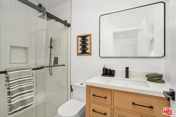 a bathroom with a sink a toilet and shower