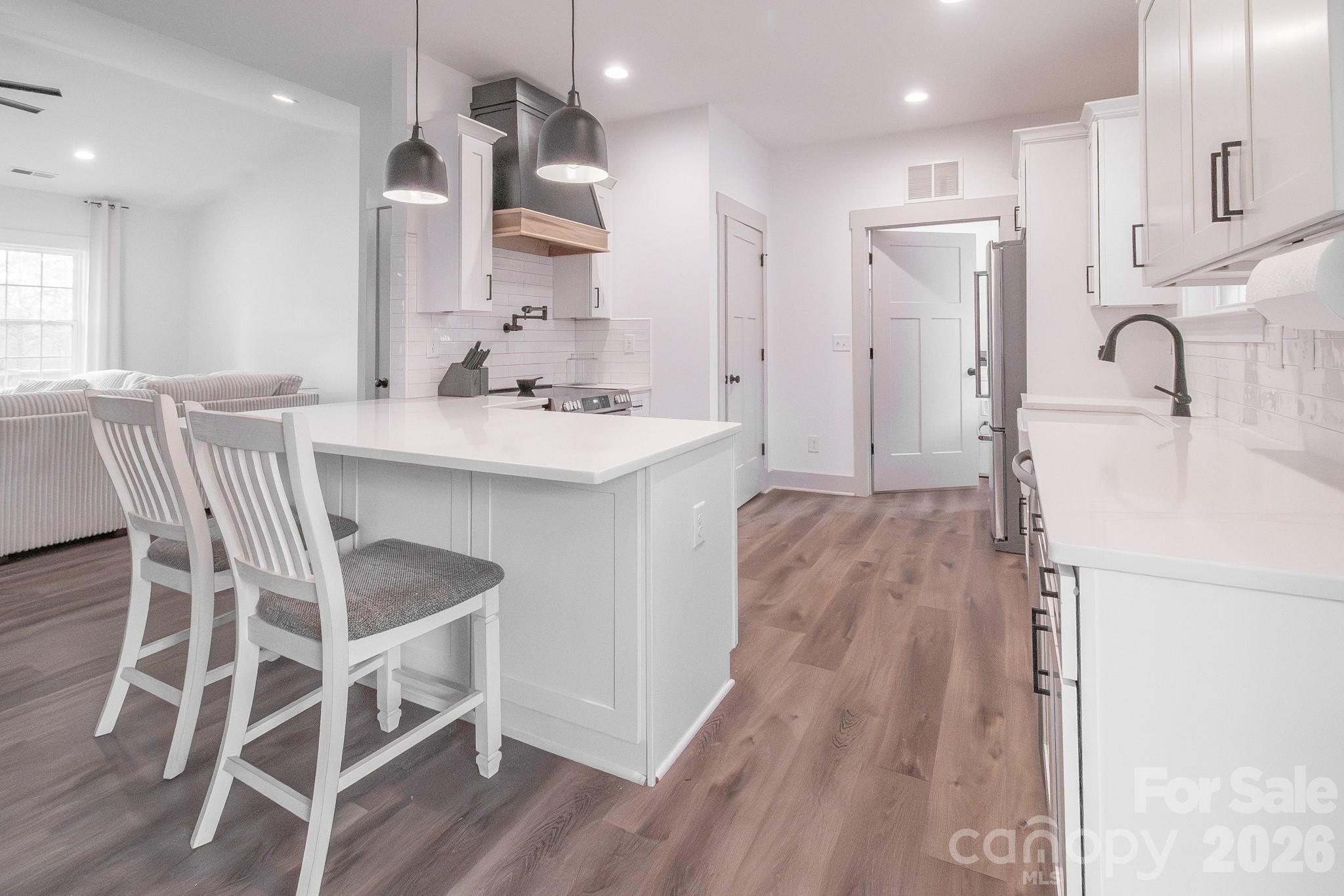 731 Miles Road Dallas, NC 28034 - Photo 15 of 45 a kitchen with kitchen island a sink stove and white cabinets
