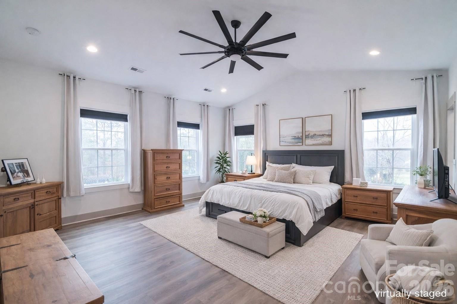731 Miles Road Dallas, NC 28034 - Photo 20 of 45 a spacious bedroom with a large bed a chandelier and windows